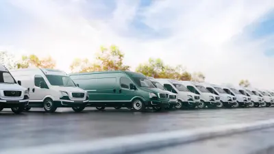 A row of white vans. In the middle is a turquoise van.