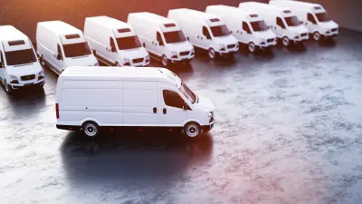 White van stands in front of a row of white vans.